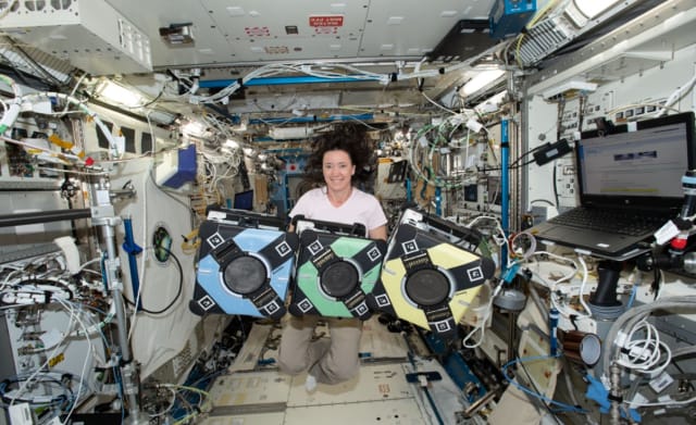 NASA astronaut Megan McArthur poses with the Astrobee robotic free-flyers in support of the Kibo Robot Programming Challenge, or Robo-Pro Challenge. Image: NASA