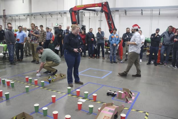 Weir Group engineers drive RC cars through a maze outlined by paper cups. The track simulates navigating hazards like mine bridges. Image: Weir Group 