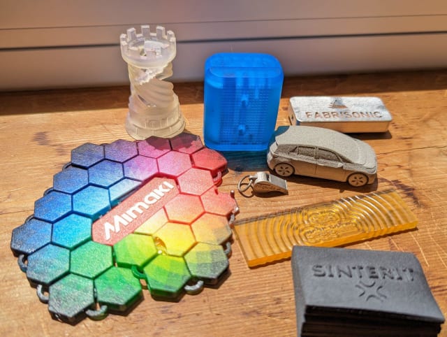 [3D printed swag from, clockwise from top left: Formlabs, Formlabs, Fabrisonic, HP, Digital Metal, polySpectra, Sinterit, and Mimaki // Image Source: Author]