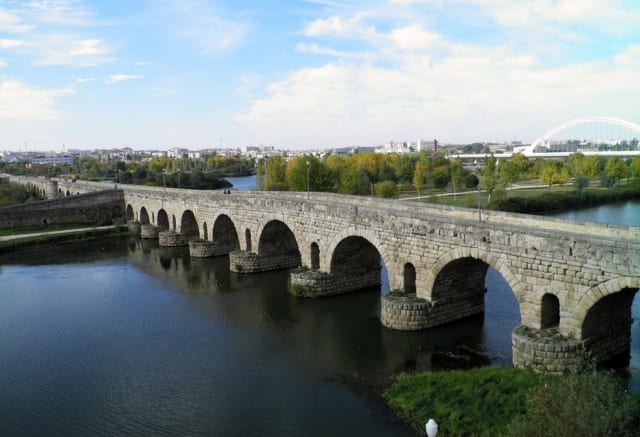 The Puente Romano Bridge is the oldest bridge in the world. It currently functions as a pedestrian bridge. Note the openings in the piers to allow for floodwater passage. Stock photo.