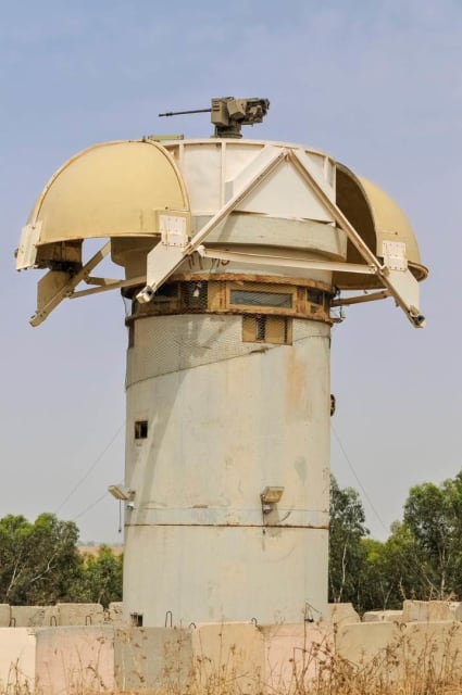 Israeli Defense Force (IDF)-operated Sentry Tech tower showing gun and hemispherical protective cover retracted near the Israeli-Gaza border. Stock photo.