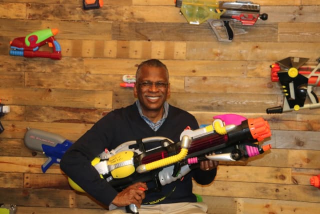 Lonnie Johnson poses with one of the many models of his most famous invention, the Super Soaker. (Image: Lonnie Johnson.)